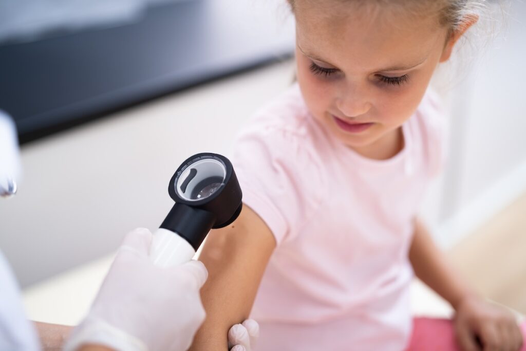 A dermatologist treating a child with pediatric-friendly treatments.